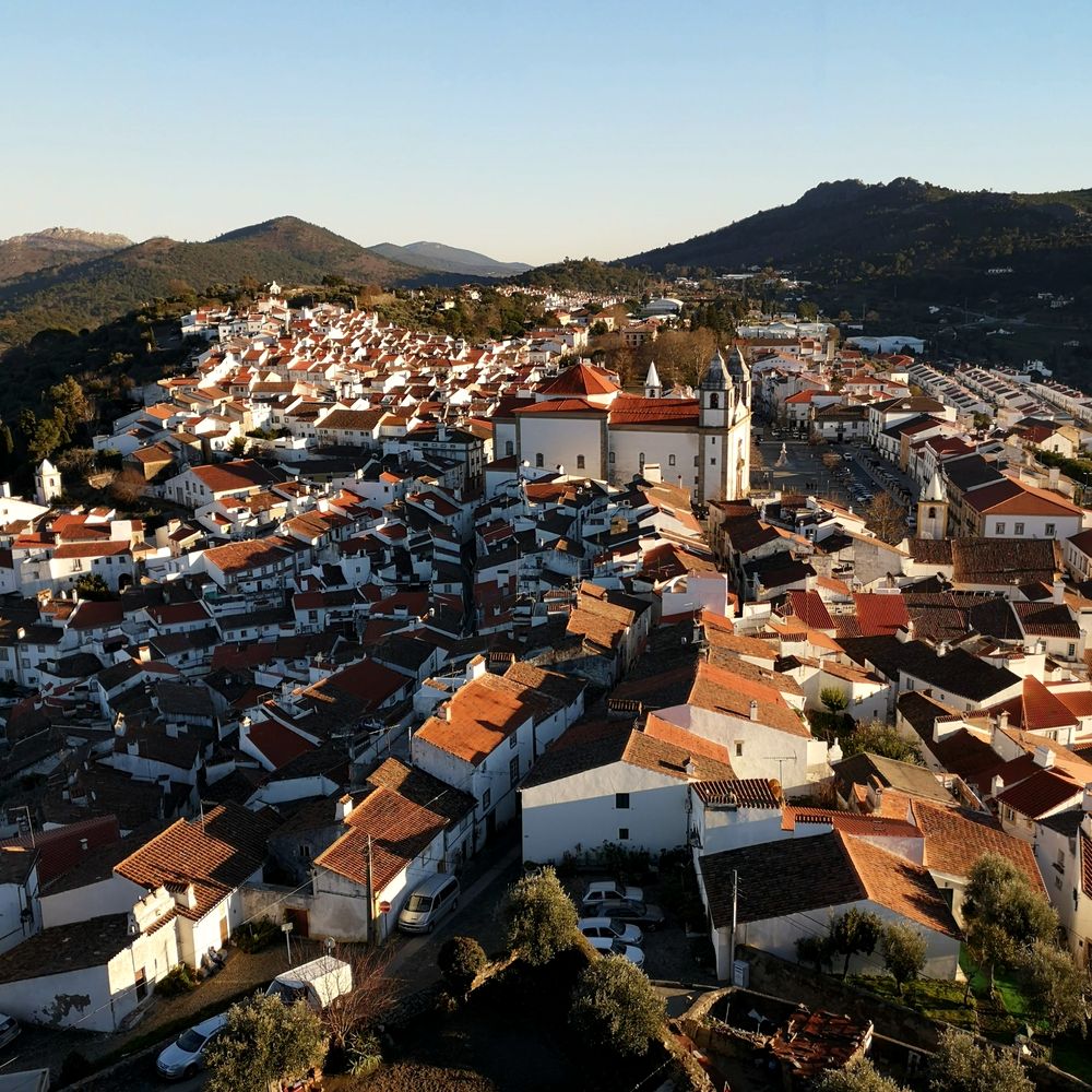 Tejados de Castelo de Vide con la iglesia de dos torres y la sierra al fondo